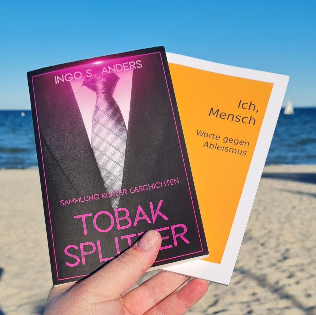 Ich halte an einem sonnigen Tag zwei Bücher in den Händen: Tobaksplitter, Sammlung kurzer Geschichten von Ingo S. Anders und Ich, Mensch Worte gegen Ableismus. Im Hintergrund blauer Himmel, das Meer und Sandstrand.