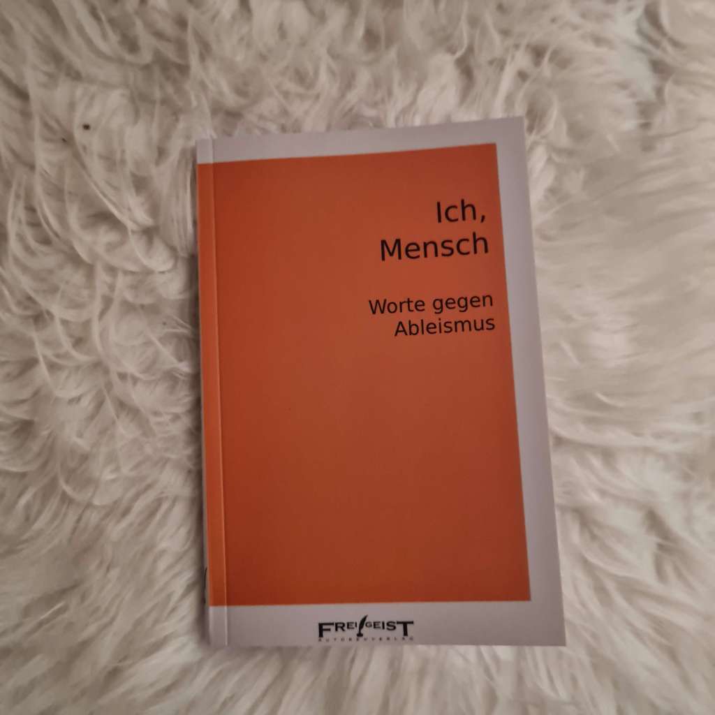 Ein Buchcover. Schwarze Schrift auf orangefarbenem Grund: Ich, Mensch Worte gegen Ableismus Frei!Geist Autorenkollektiv