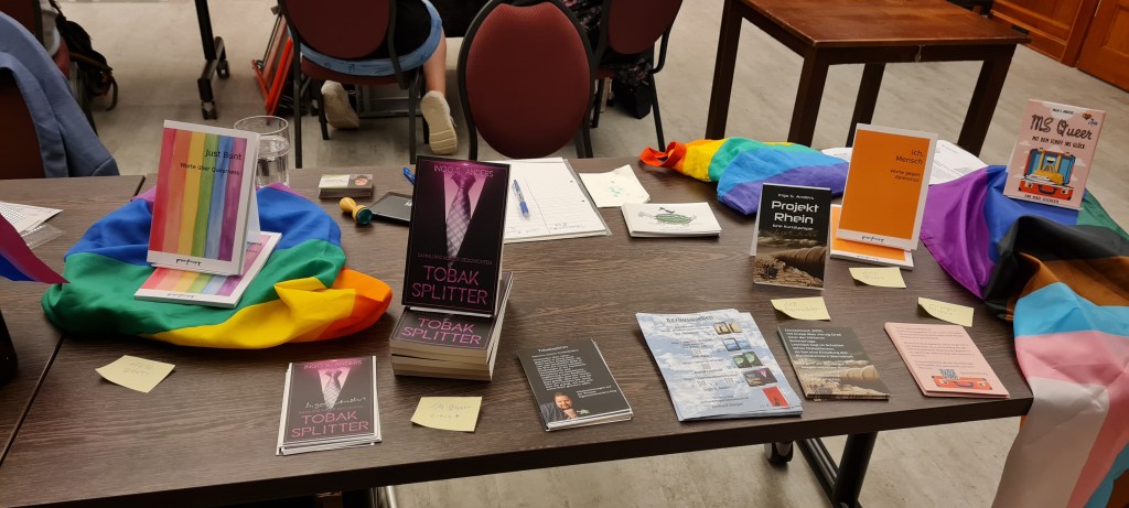Auf einem Tisch ausgestellte Bücher und ausgelegte Flyer.